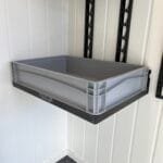 a grey plastic bin on a white wall. starflex modulsystem med euroboks og euroboks holder samt modulskinner